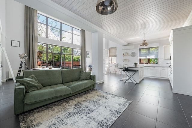 open concept white kitchen and living room with dark flooring and a green statement couch